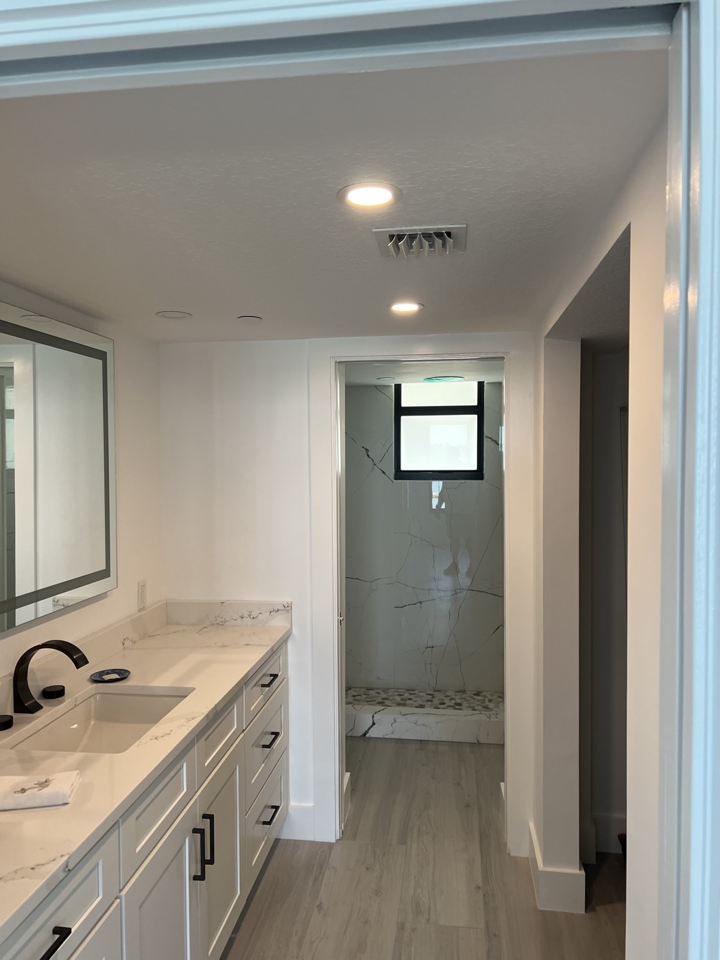 A double vanity with stone counters, and the walk-in shower in the second new bathroom.