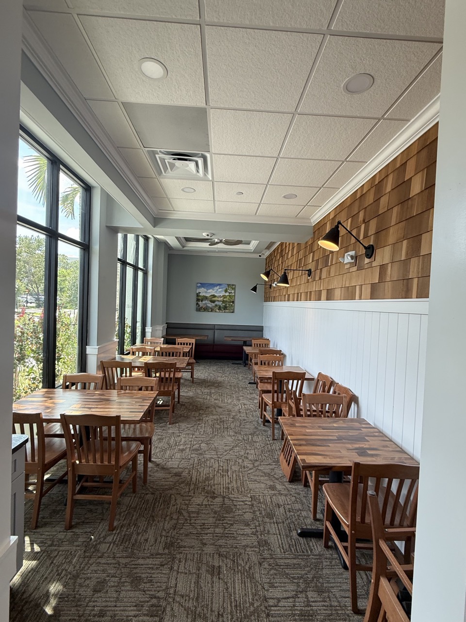 The dining room, with a shingled accent wall and wall sconces.