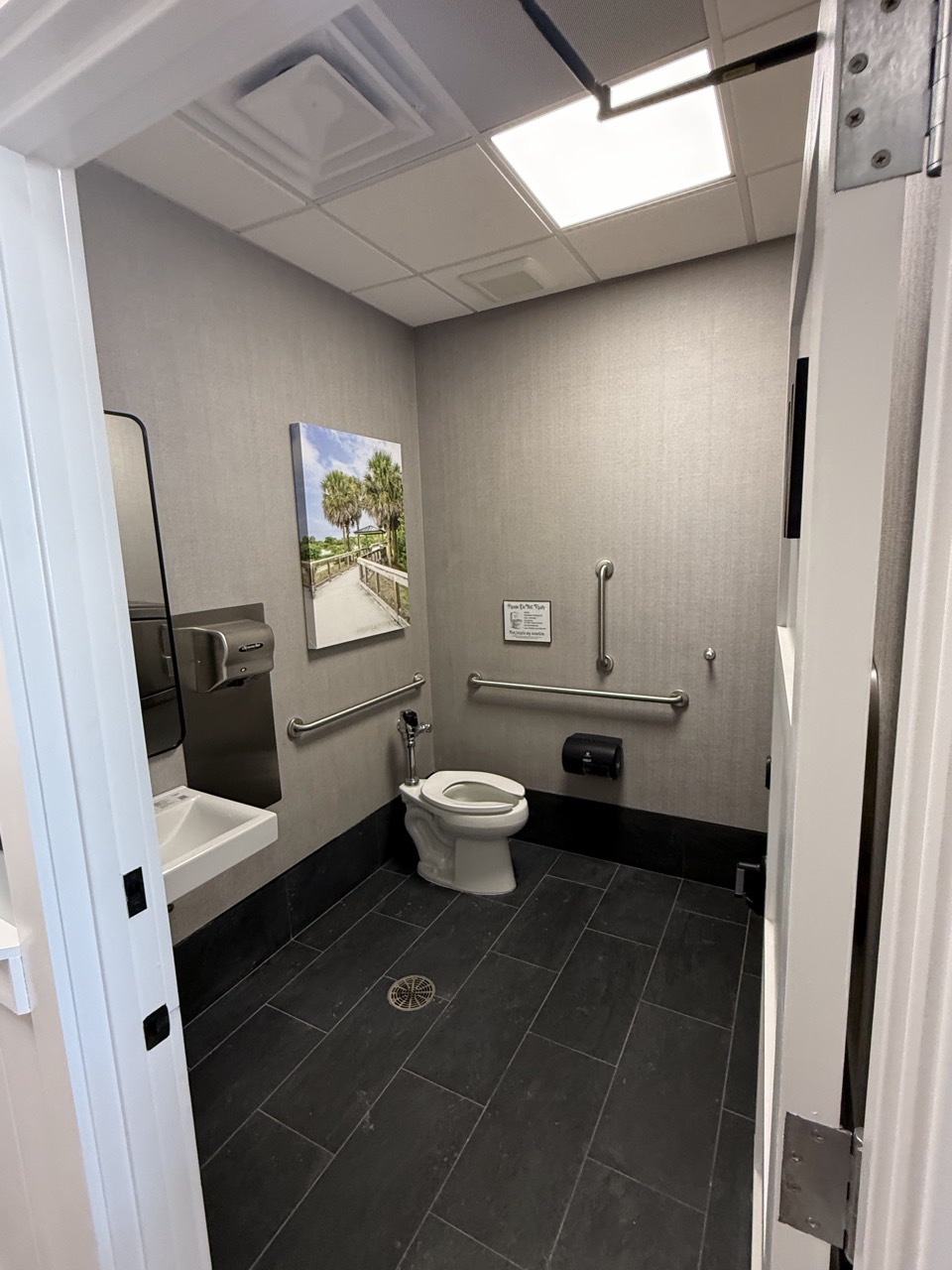 An accessible restroom, with grab bars and tiled finishes.